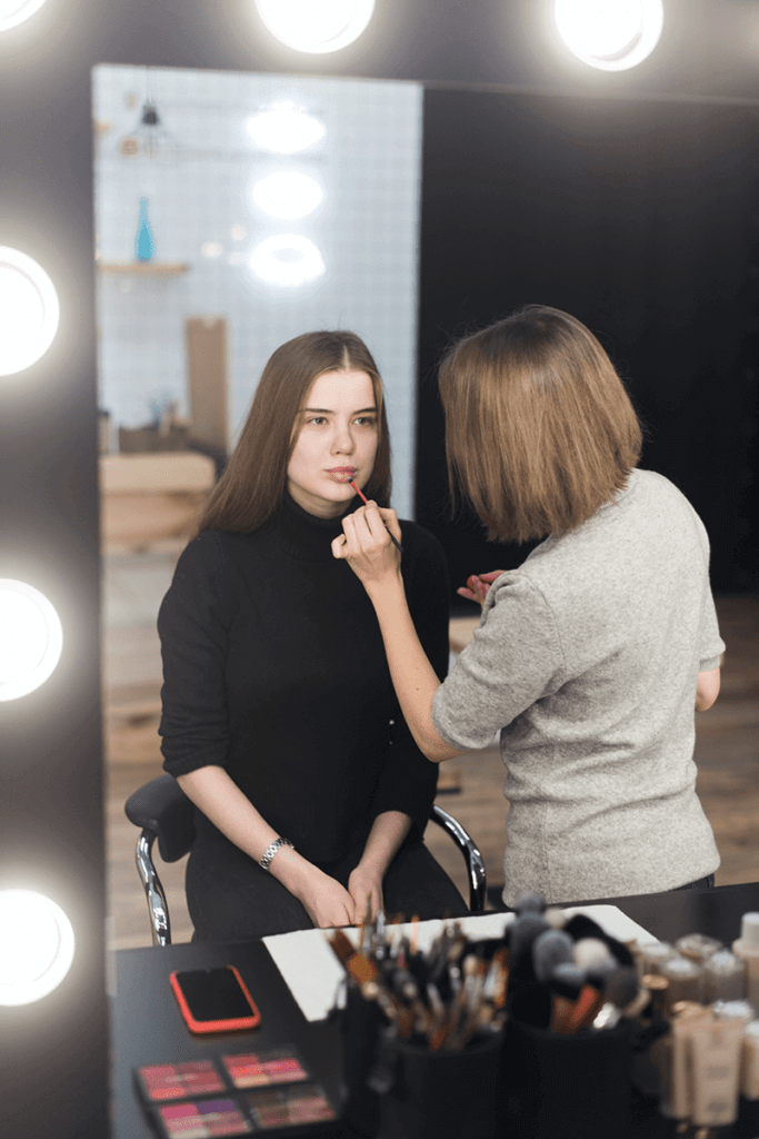 Artist applying makeup to a model